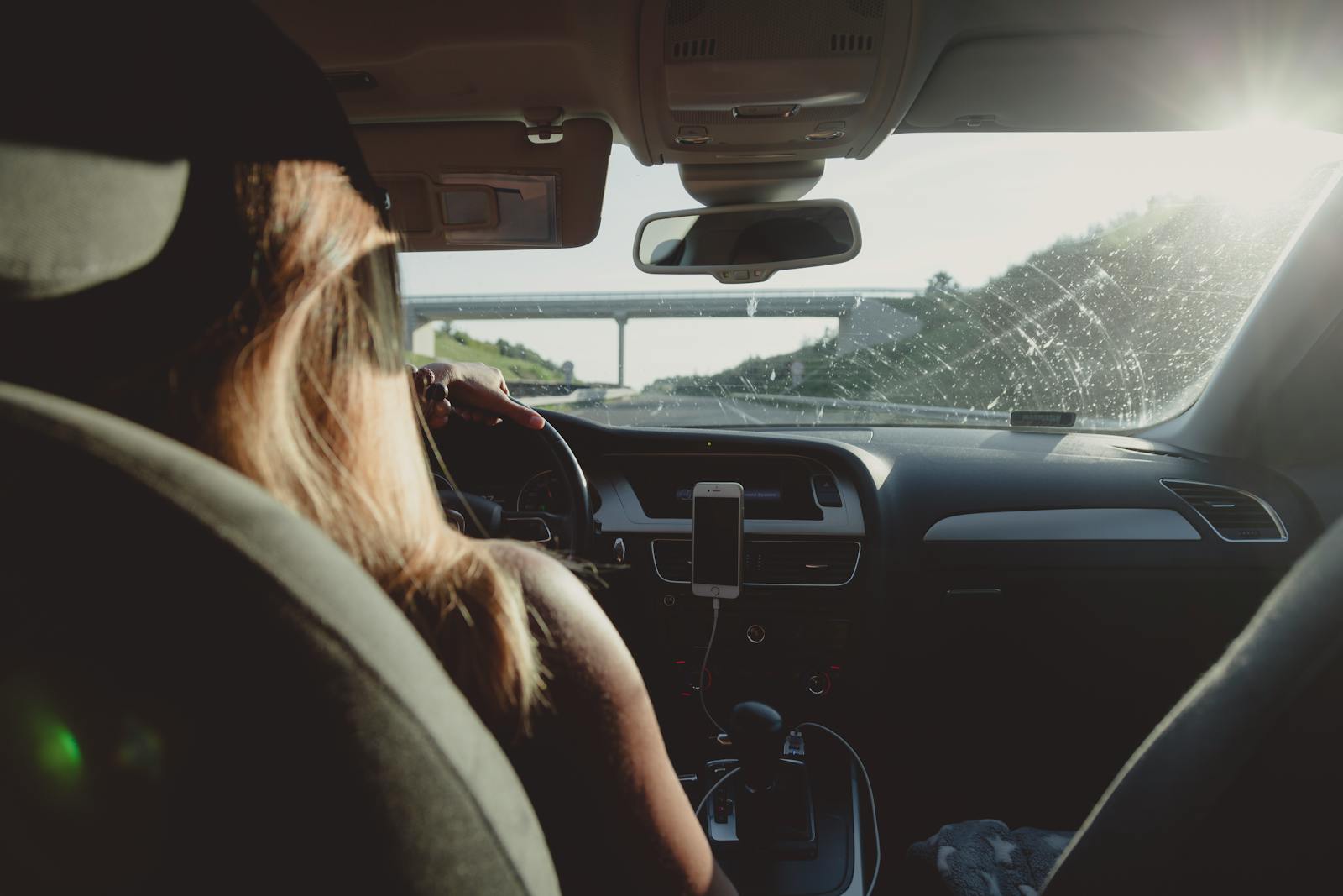 Woman driving on a highway during daytime, capturing road trip mood, auto.